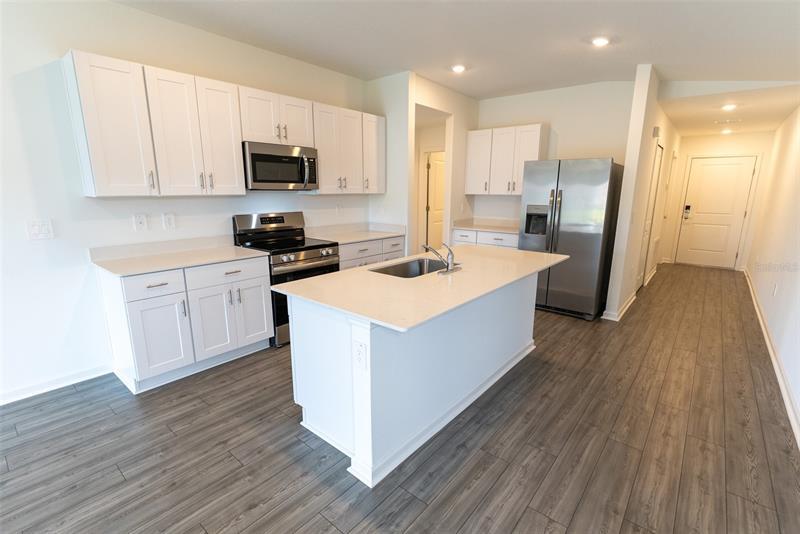 Kitchen with quartz island and white shaker cabinets