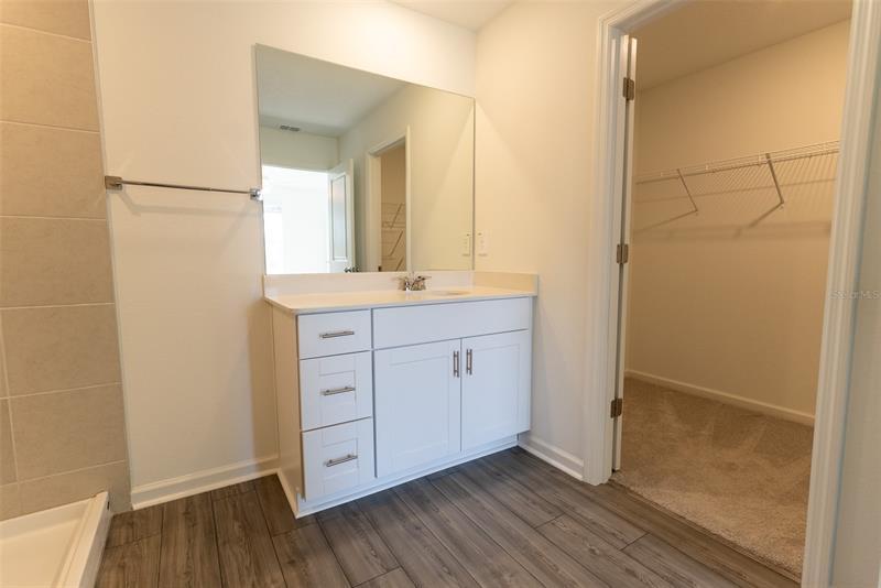 Primary bathroom with double vanity and walk-in closet